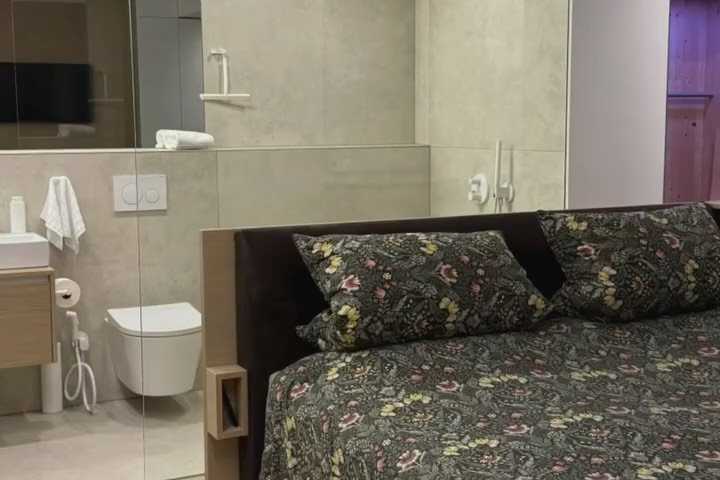 Hotelzimmer mit offenem Bad hinter Glas