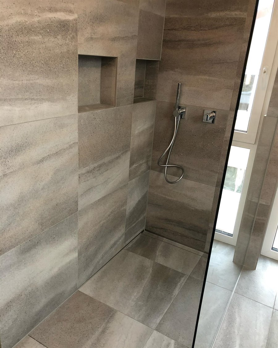 Bad mit bodengleicher Dusche in Naturstein